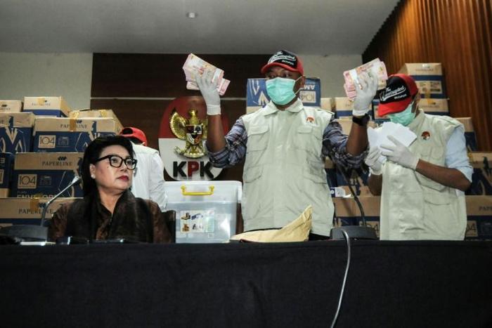 Corruption eradication commission officers in Jakarta show boxes of Indonesian currency totalling over 560,000 USD seized from a lawmaker's office ahead of elections