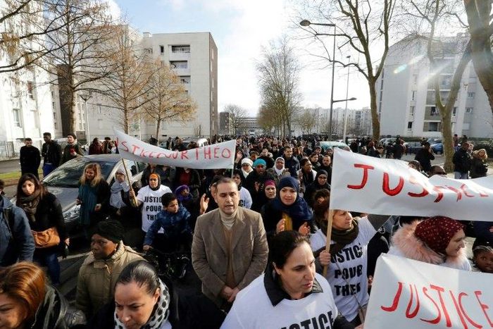 People holding signs reading "Justice for Theo" march through Aulnay-sous-Bois, north of Paris