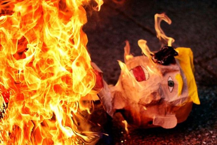An effigy representing US President Donald Trump is burnt during a protest against his inauguration in Mexico City