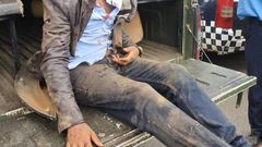 Naftali Njahi Kinuthia at the back of a police Land Cruiser after he was stoned by bodaboda operators outside Moi Teaching and Referral Hospital (Twitter)