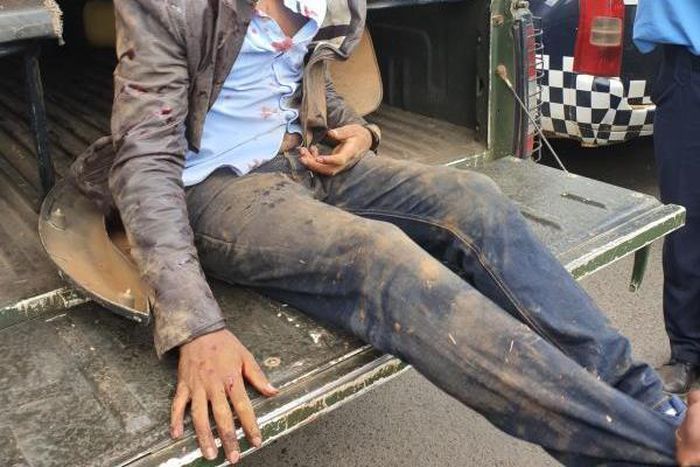 Naftali Njahi Kinuthia at the back of a police Land Cruiser after he was stoned by bodaboda operators outside Moi Teaching and Referral Hospital (Twitter)