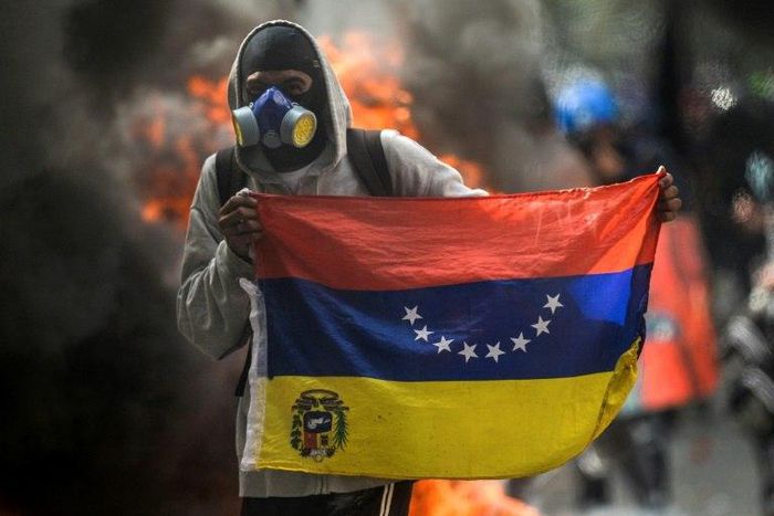 A hooded demonstrator protests against the government of President Nicolas Maduro in Caracas on May 31, 2017