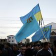 Crimean Tatars hold Ukrainian and Tatar flags at a memorial ceremony marking the 70th anniversary of the deportation of Tatars from Crimea, near a Mosque in Simferopol on May 17, 2014