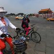 Cyclists ride past Tiananmen Gate on the eve of the 28th anniversary of the June 4, 1989 crackdown on pro-democracy protests in Beijing