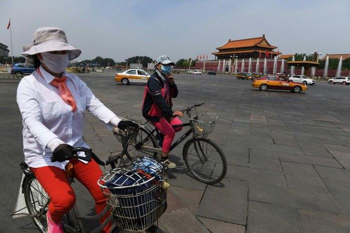 Cyclists ride past Tiananmen Gate on the eve of the 28th anniversary of the June 4, 1989 crackdown on pro-democracy protests in Beijing