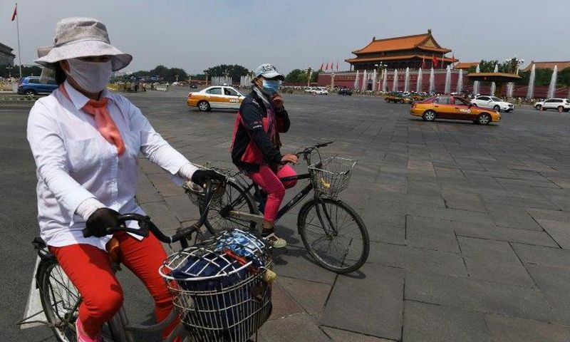 Cyclists ride past Tiananmen Gate on the eve of the 28th anniversary of the June 4, 1989 crackdown on pro-democracy protests in Beijing