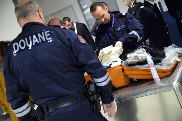 French customs officers check luggage at Roissy Charles de Gaulle airport, north of Paris on March 17, 2015