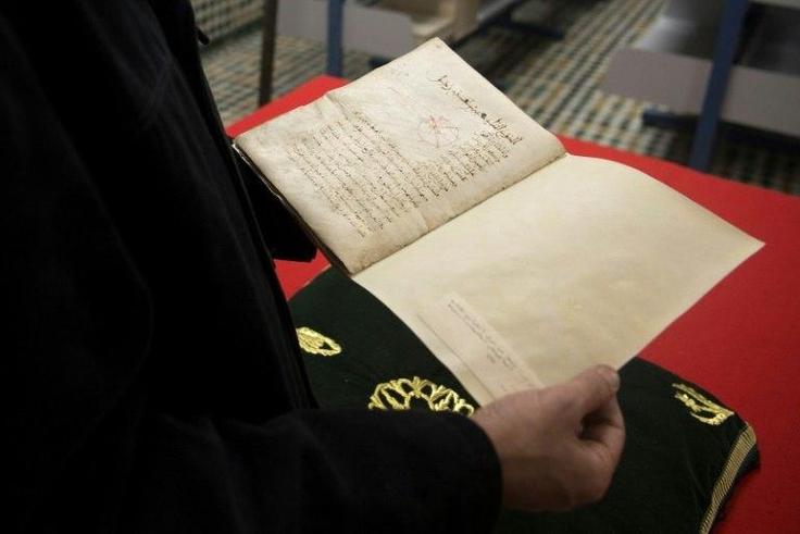 A man reads a manuscript on astronomy by renowned tenth century Muslim philosopher Al-Farabi, at the al-Qarawyin Library on November 21, 2016