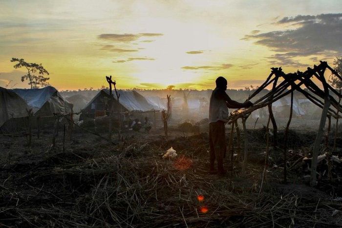 A man builds a tent at sunset in a camp for internally displaced people in Kaga Bandoro, Central African Republic