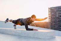 Mid adult man exercising outdoors, in yoga position