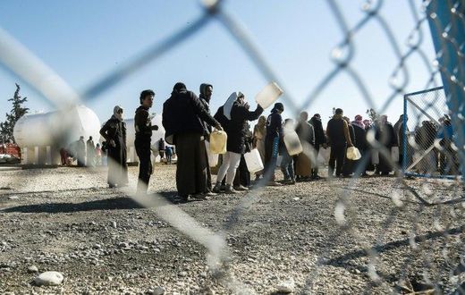 Refugees queue for heating fuel at a UN refugee camp in Syria's Hasakeh province on January 29, 2017