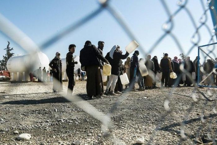 Refugees queue for heating fuel at a UN refugee camp in Syria's Hasakeh province on January 29, 2017