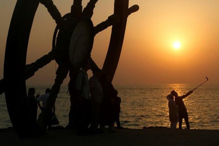 Tourists take a selfie on the seafront on Iran's southern resort island of Kish