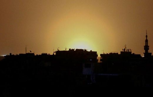 A photo taken from the rebel-held town of Douma shows flames rising in the distance which are believed to be coming from Damascus International Airport following an explosion early in the morning of April 27, 2017