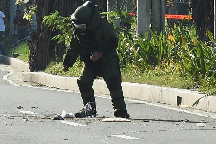 A police bomb disposal expert works to defuse a bomb found in a rubbish bin near the US embassy in Manila on November 28, 2016
