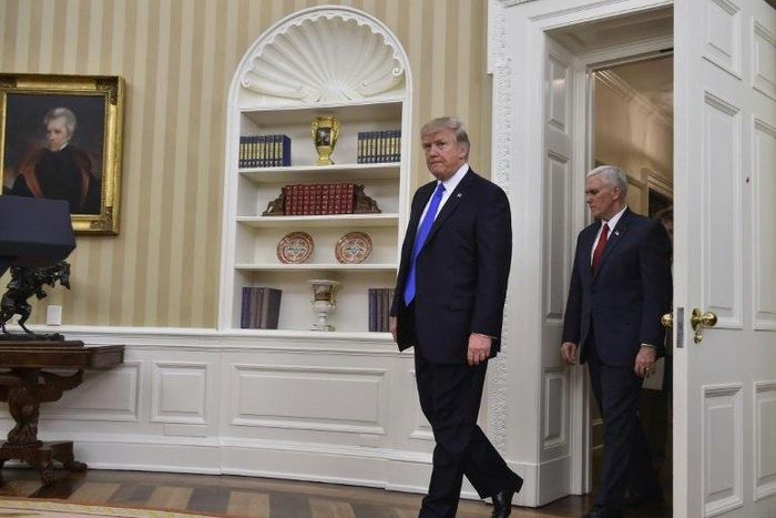 US President Donald Trump and Vice President Mike Pence walk into the Oval Office at the White House