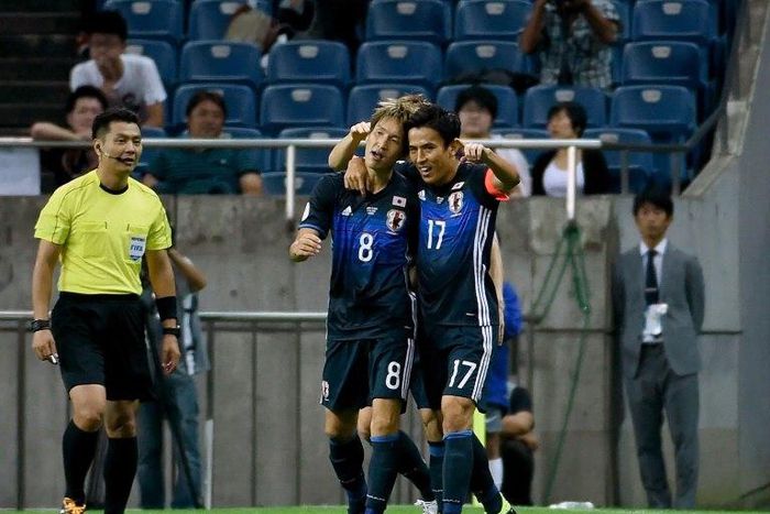 Japanese forward Genki Haraguchi (centre) celebrates with captain Makoto Hasebe after scoring the opening goal against Iraq during a World Cup qualifier in Saitama on October 6, 2016