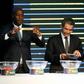 Fomer Senegalese football player Khalilou Fadiga (L) shows a piece of paper bearing the name of Ouganda next to Confederation of African Football (CAF) secretary general Hicham El Amrani during the 2017 African Cup of Nations draw ceremony