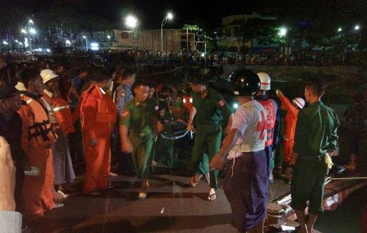 Myanmar soldiers and members of a rescue team carry the body of a passenger after a ferry sank in the Nga Wun River in Pathein with at least 20 dead