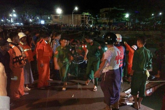 Myanmar soldiers and members of a rescue team carry the body of a passenger after a ferry sank in the Nga Wun River in Pathein with at least 20 dead