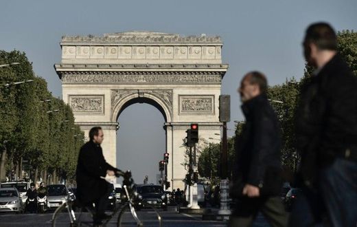 Pedestrians and vehicles on the Champs-Elysees in Paris on April 21 ,2017, a day after a gunman opened fire on police on the avenue, killing a policeman and wounding two others