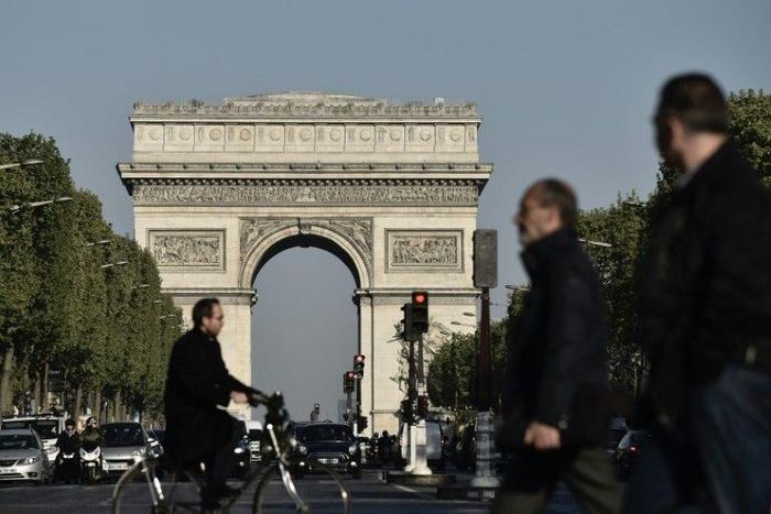 Pedestrians and vehicles on the Champs-Elysees in Paris on April 21 ,2017, a day after a gunman opened fire on police on the avenue, killing a policeman and wounding two others