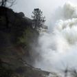 Water rushes down a spillway as an emergency measure at the Oroville Dam in Oroville, California on February 13, 2017