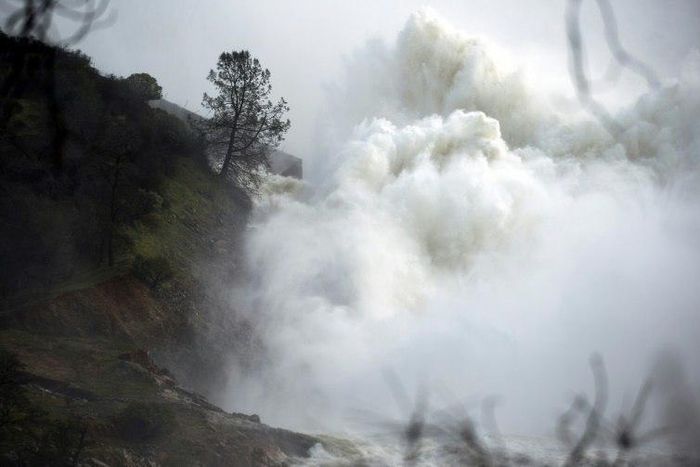 Water rushes down a spillway as an emergency measure at the Oroville Dam in Oroville, California on February 13, 2017