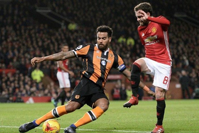 Hull City's Tom Huddlestone (L) clears the ball from the path of Manchester United's Juan Mata during their League Cup semi-final first leg match, at Old Trafford in Manchester, on January 10, 2017