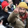 French farmer Cedric Herrou flashes the victory sign as he leaves the Nice courthouse on February 10, 2017