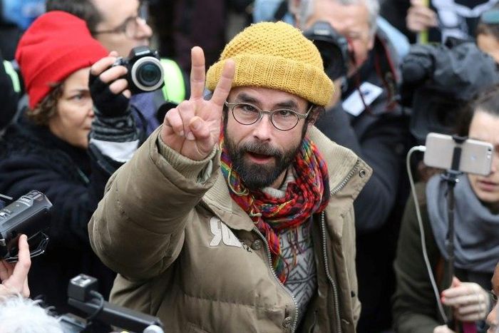 French farmer Cedric Herrou flashes the victory sign as he leaves the Nice courthouse on February 10, 2017