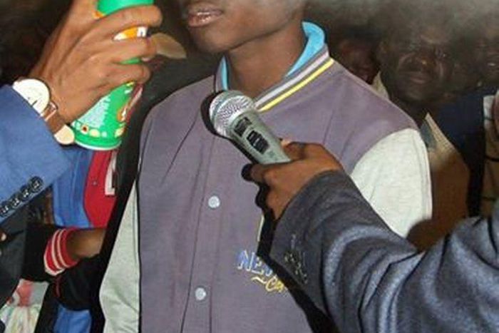 Pastor Lesotho spraying boy with doom