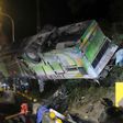 A bus that crashed along a highway is lifted by cranes in Taipei on February 14, 2017