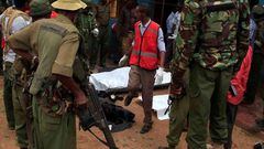 Police officers stand by dead bodies after an attack by Islamist militants from the Somali group al Shabaab in Mandera, Kenya, October 6, 2016.