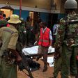Police officers stand by dead bodies after an attack by Islamist militants from the Somali group al Shabaab in Mandera, Kenya, October 6, 2016.
