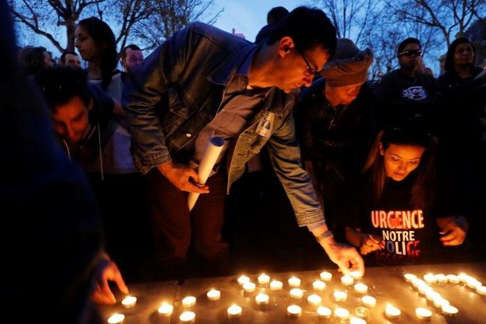 Demonstrators light candles during a protest in Paris over the death of Chinese Liu Shaoyo, shot dead by French police