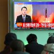 People watch the news showing file footage of a North Korean missile launch at a railway station in Seoul on February 12, 2017
