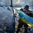 An anti-government opposition activist places European Union and Ukrainian flags side by side at a barricade in Kiev on February 2, 2014