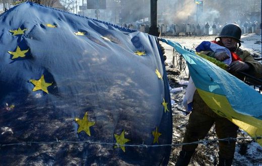 An anti-government opposition activist places European Union and Ukrainian flags side by side at a barricade in Kiev on February 2, 2014