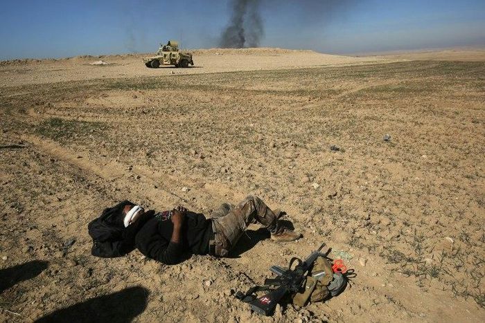 An Iraqi soldier waits to be evacuated, after he was wounded in an explosives-laden vehicle attack claimed by the Islamic State group near Mosul on February 20, 2017