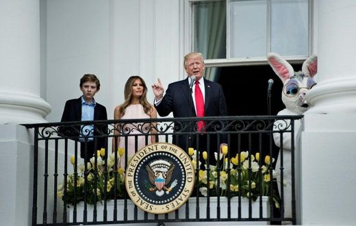 US President Donald Trump, alongside son Barron Trump (L) and US First Lady Melania Trump (2L), speaks during the Easter Egg Roll on the South Lawn of the White House in Washington, DC on April 17, 2017