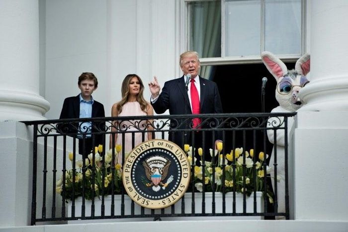 US President Donald Trump, alongside son Barron Trump (L) and US First Lady Melania Trump (2L), speaks during the Easter Egg Roll on the South Lawn of the White House in Washington, DC on April 17, 2017