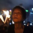 An elderly participant holds a candle with others as they attend a candlelight vigil at Hong Kong's Victoria Park on June 4, 2017, to mark the 28th anniversary of the 1989 Tiananmen crackdown in Beijing