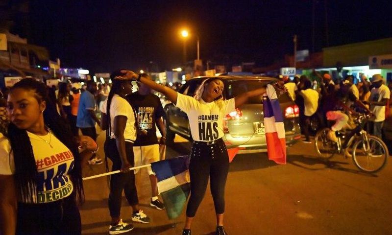 People celebrate in the streets of Banjul on January 21, 2017 after hearing of the confirmed departure of former Gambian leader Yahya Jammeh from the country