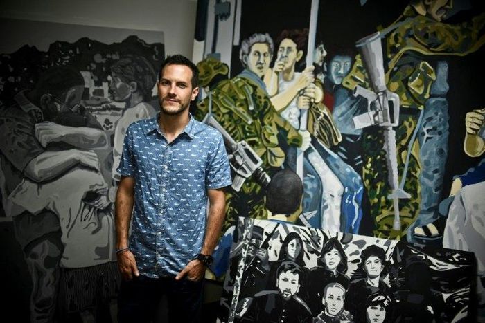Colombian artist Juan Daniel Otoya, 28, poses beside his work in Cali, department of Valle del Cauca, Colombia, on January 12, 2017
