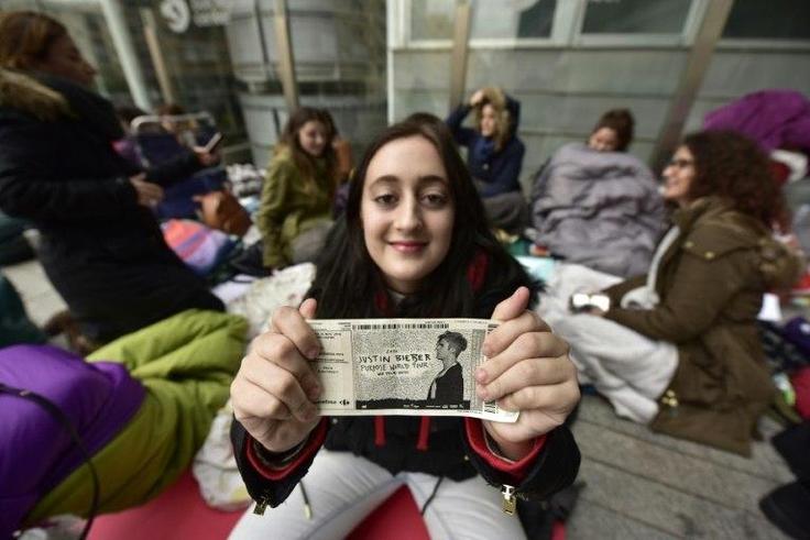 A fan of Canadian popstar Justin Bieber poses with her ticket outside the concert hall in Madrid, on November 18, 2016