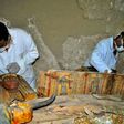Members of an Egyptian archaeological team work on April 18, 2017 on a wooden coffin discovered in a 3,500-year-old tomb in the Draa Abul Nagaa necropolis, near the southern Egyptian city of Luxor