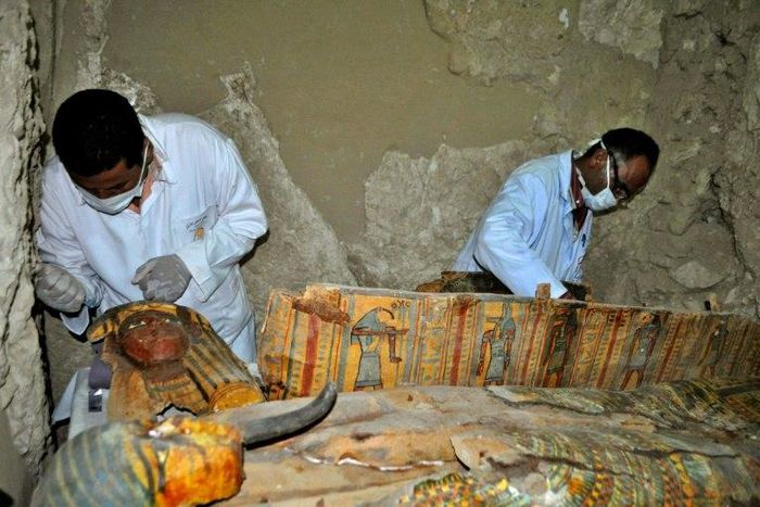 Members of an Egyptian archaeological team work on April 18, 2017 on a wooden coffin discovered in a 3,500-year-old tomb in the Draa Abul Nagaa necropolis, near the southern Egyptian city of Luxor