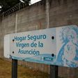 Police agents stand guard next to a sign that reads "Sage home Virgen de la Asuncion" at the children's shelter entrance after 40 girls died during a fire on March 8, in San Jose Pinula, on March 15, 2017