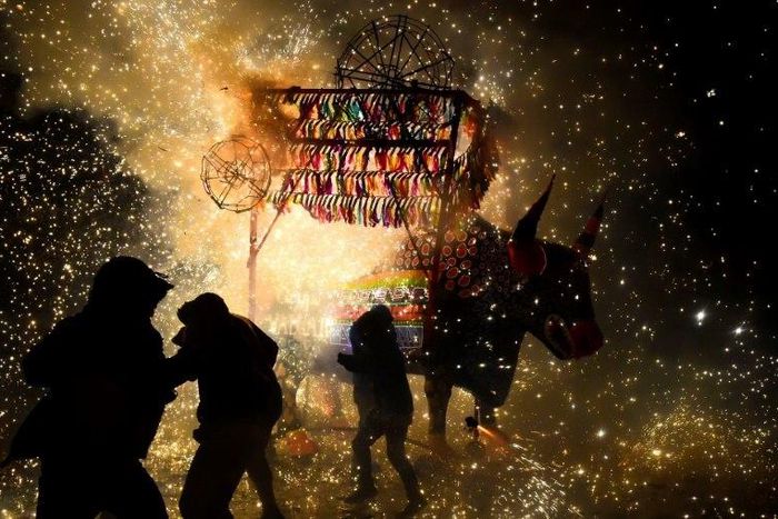 People run away from fireworks exploding around them next to a traditional "torito" (little bull) made of paper, wood and fireworks, during the San Juan de Dios festival in Tultepec, on March 8, 2017